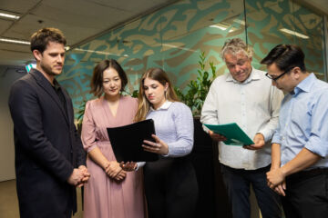 eWorks expertise team a group of five staff reviewing documents and contracts