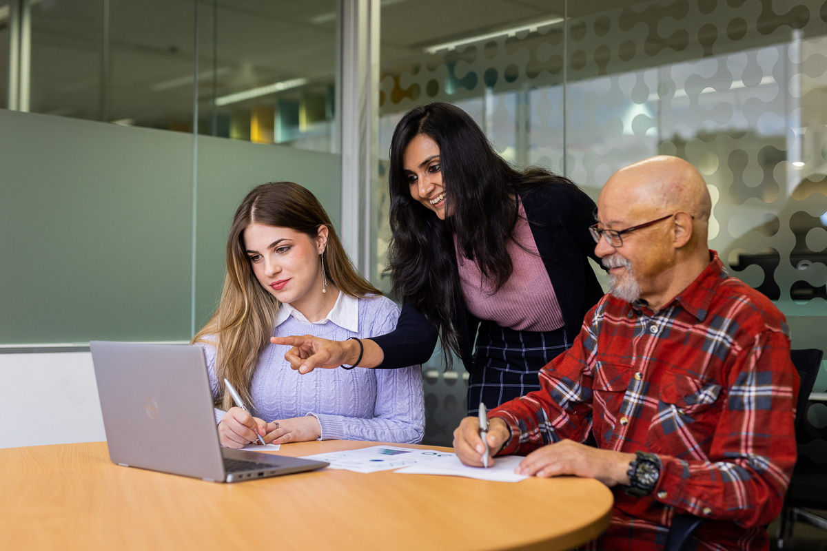 eWorks team with 3 staff reviewing information on a computer