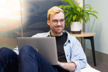 eWorks Innovative Education Technology Solutions student sitting on a bean bag with a laptop smiling