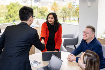 How to develop a design framework to build eLearning courses female shaking hands with male with two others at the meeting table