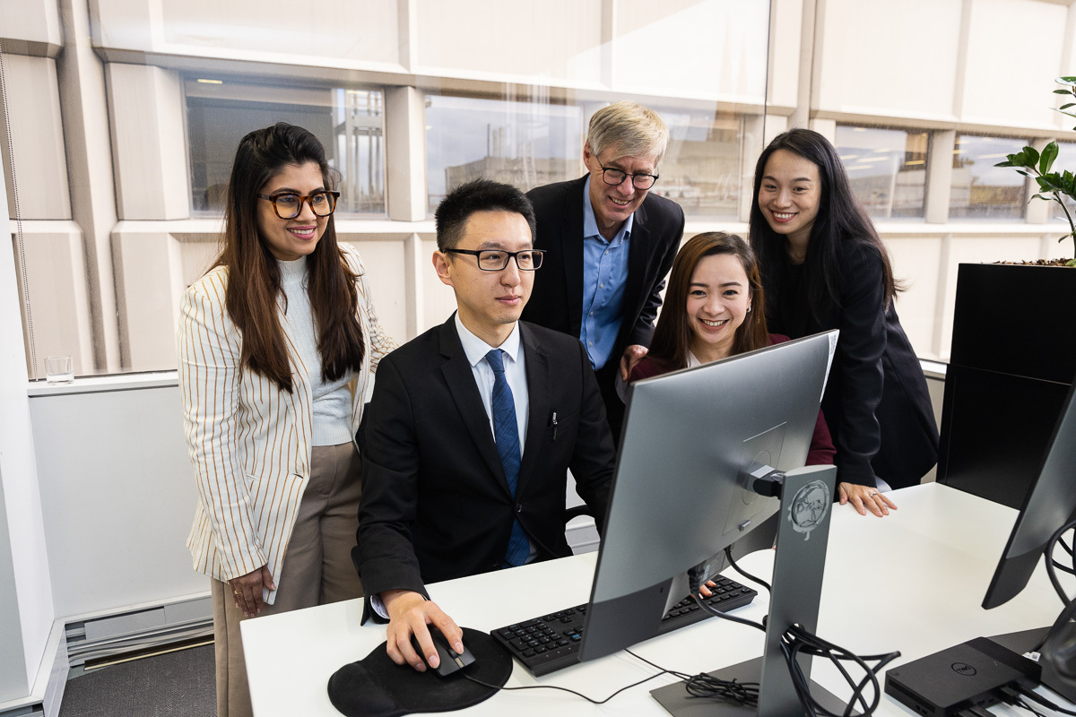 eWorks Bespoke eLearning Content with 5 people looking at a computer monitor by a workstation