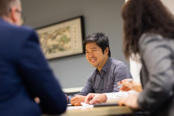 eWorks eWorks In-Person Demo male staff in meeting smiling