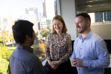 eWorks designed for optimal success 3 people next to a window smiling