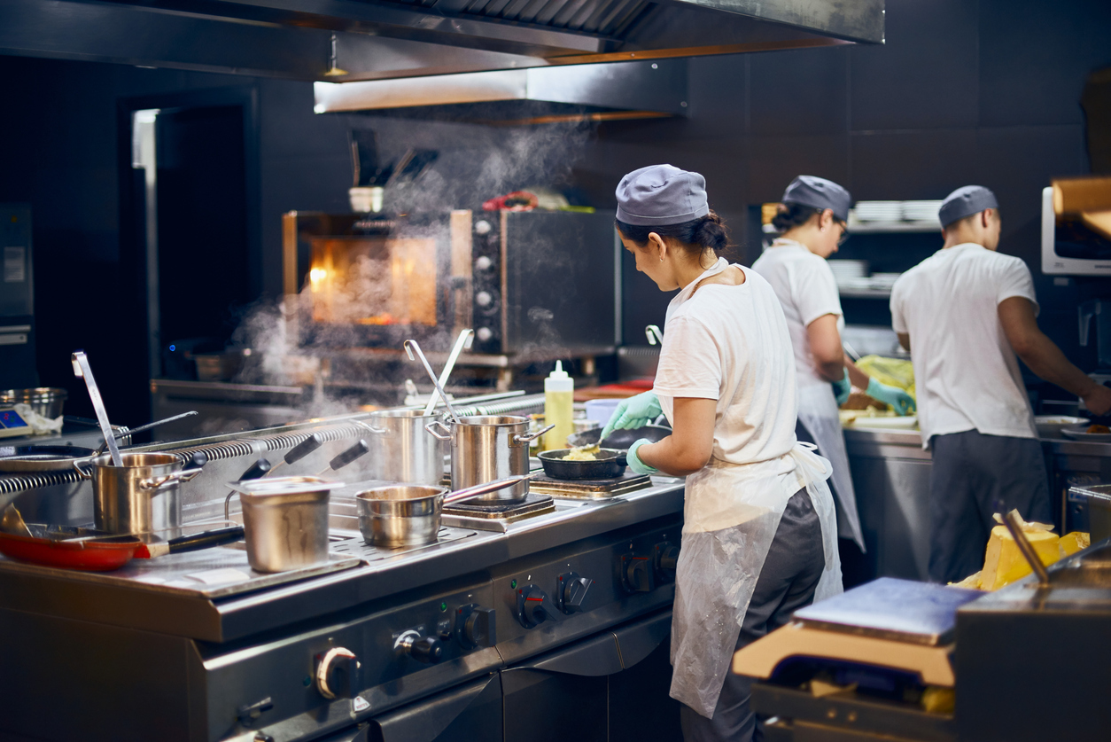 Young woman in commercial kitchen hospitality training